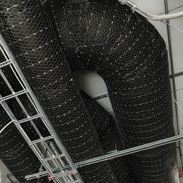 Fire-insulated ventilation ducts, cable tray, and lighting suspension rail installed near the ceiling.