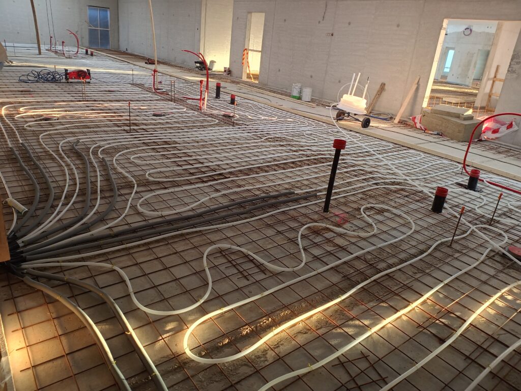 Finished underfloor heating installation in a building under construction.